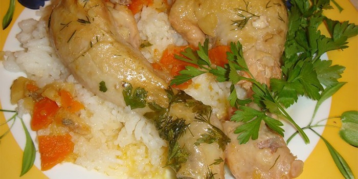 Куриные голени с овощной подливой и рисом на тарелке