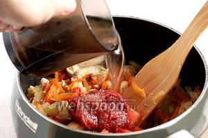 Добавить в сотейник томатную пасту или свежие помидоры, 2 щепотки сахара, чтобы нейтрализовать кислоту. Залить всё стаканом кипятка и варить примерно 10 минут.