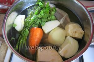 Овощи, кости и головы, часть зелени пучком, солим и заливаем холодной водой.
