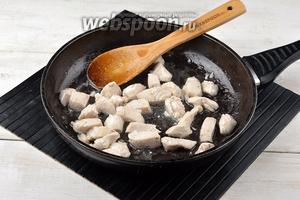 В сковороде разогреть подсолнечное масло (4 ст. л.) и обжарить в нём, помешивая, подготовленные кусочки филе до побеления (приблизительно 5 минут). Вынуть филе и выложить на блюдо.